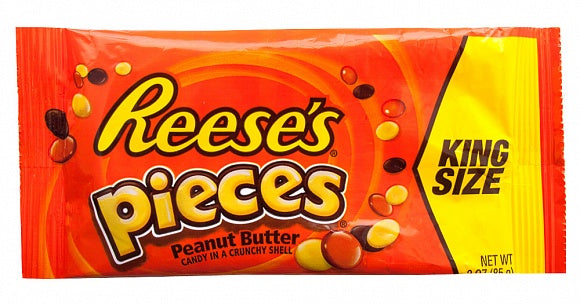 Lively image showcasing Reese's Pieces King Size Bags with candies playfully spilling out, surrounded by people sharing and enjoying them, set against a colourful backdrop, reflecting the fun and communal spirit of this beloved American candy