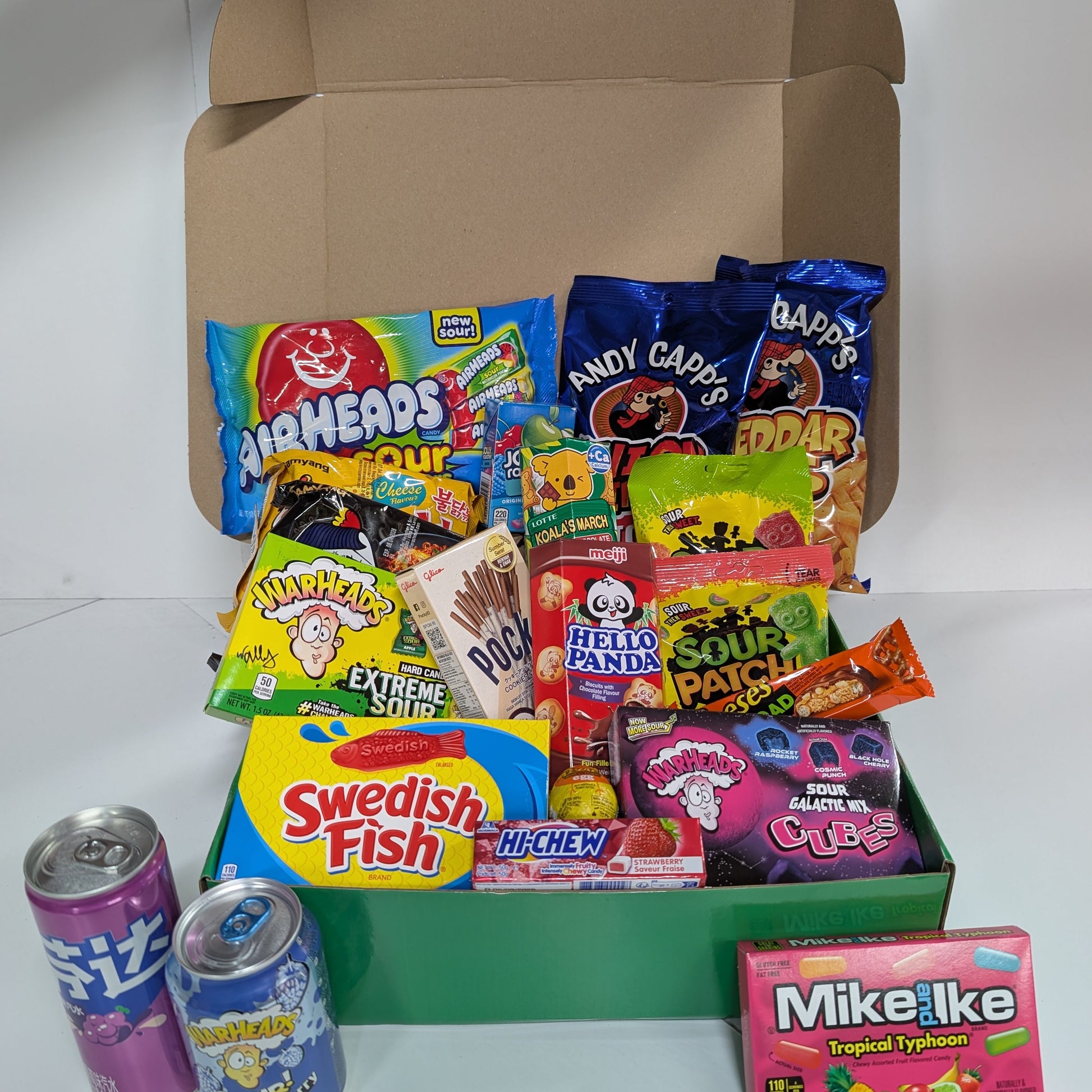 Assorted candy and soda pack in a box on a white background