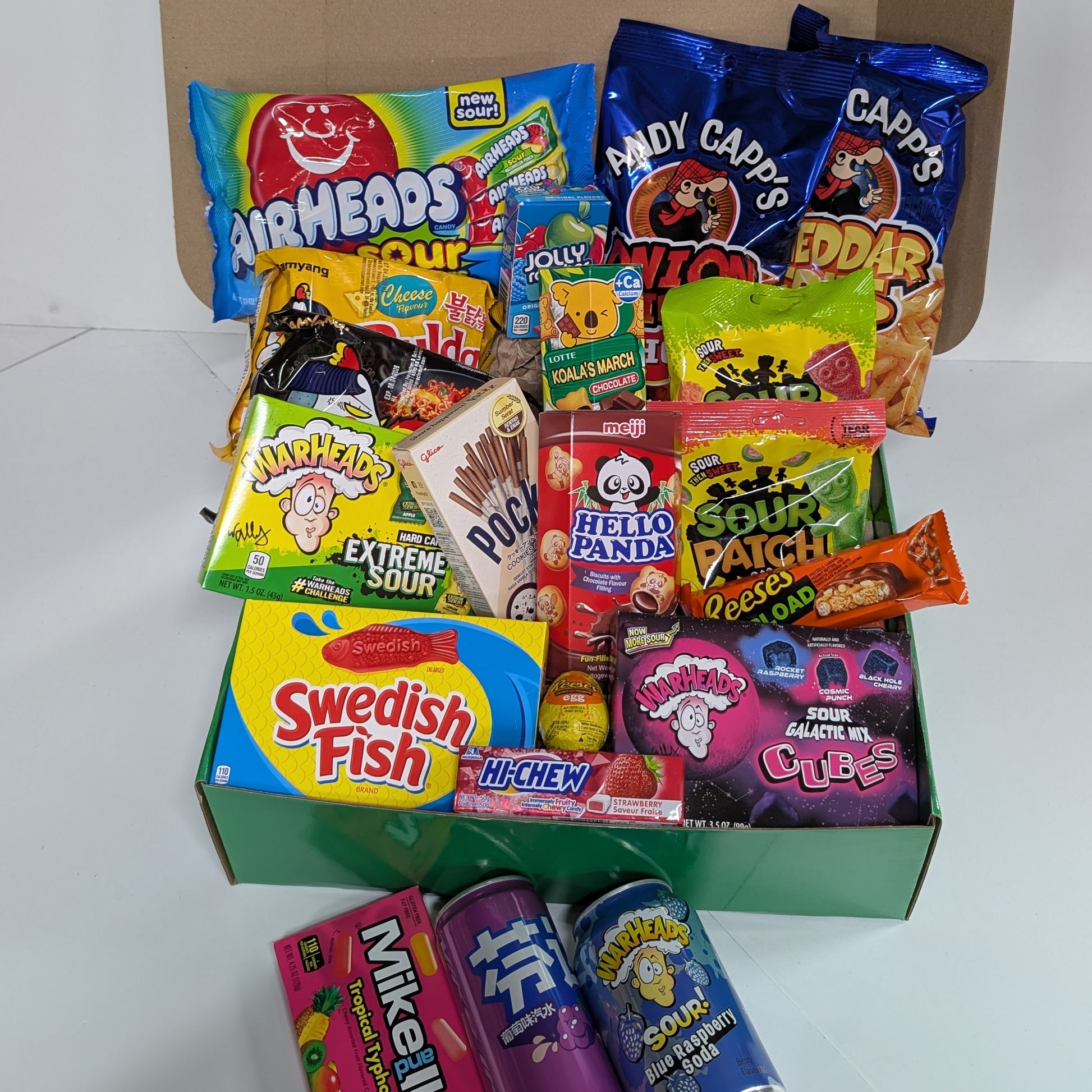 Assorted candy and snack box with visible brands on a white background