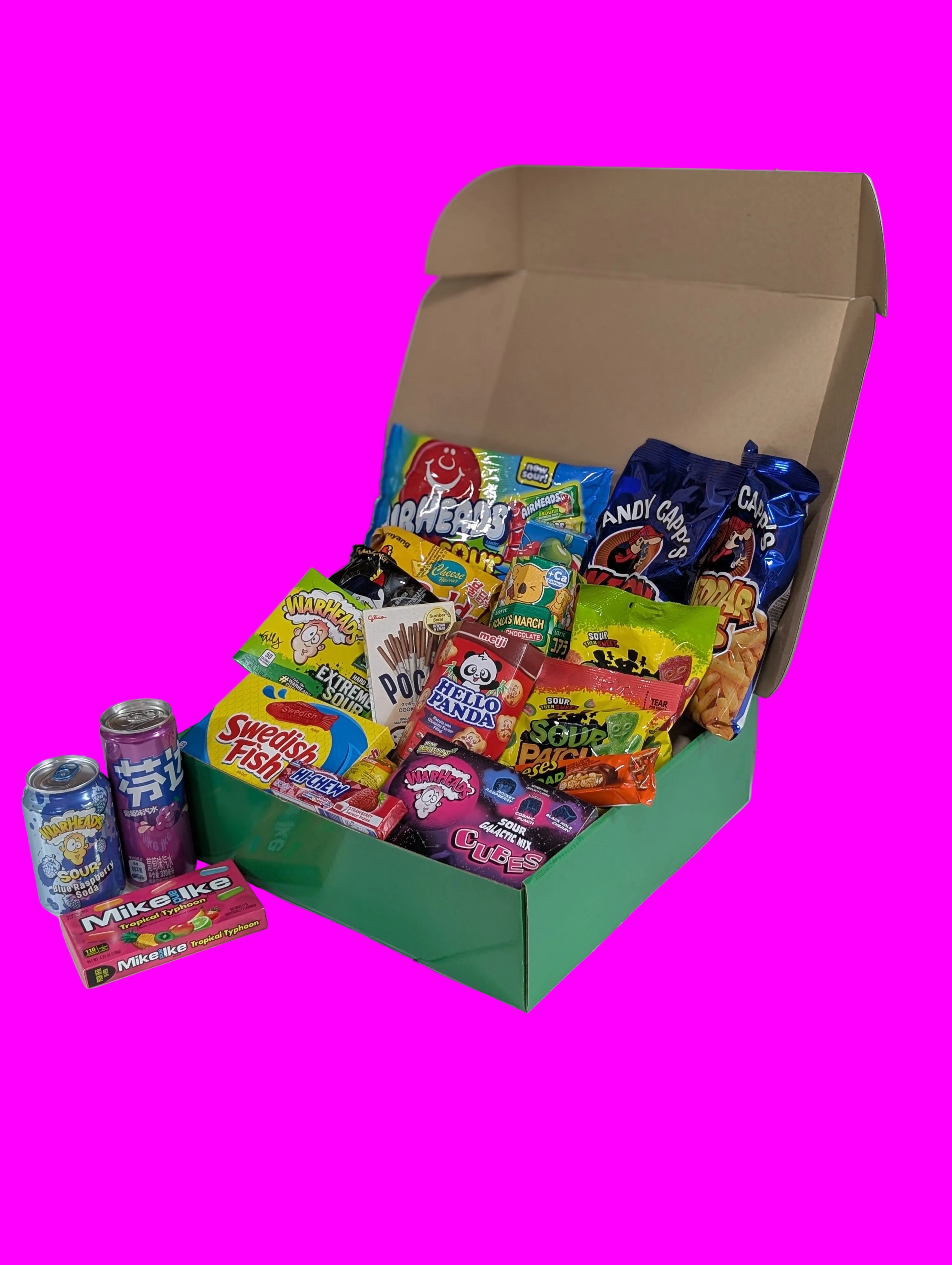 Open box filled with various colorful candy packages on a white surface.