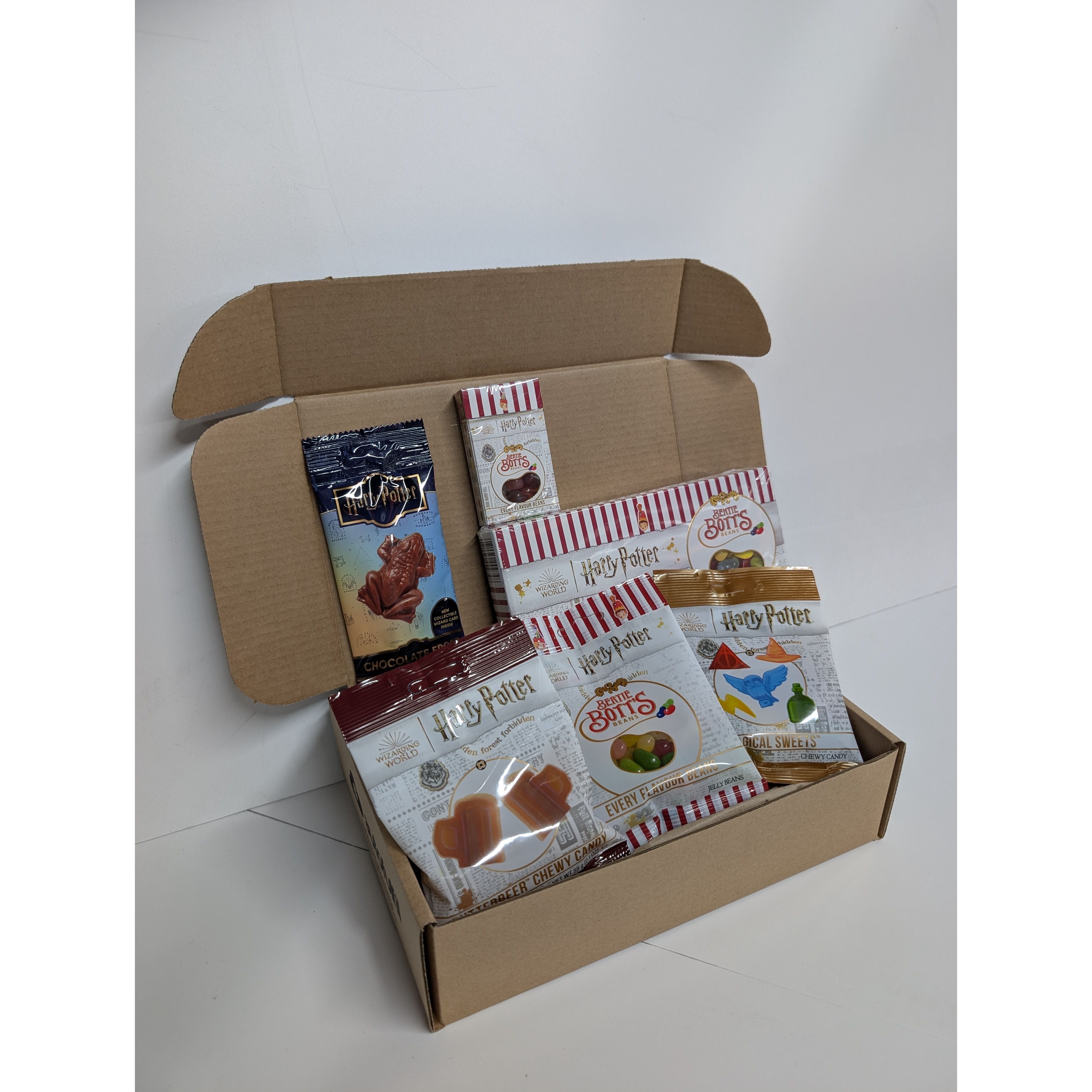 Open cardboard box containing 'Harry Potter' themed snacks on a white background