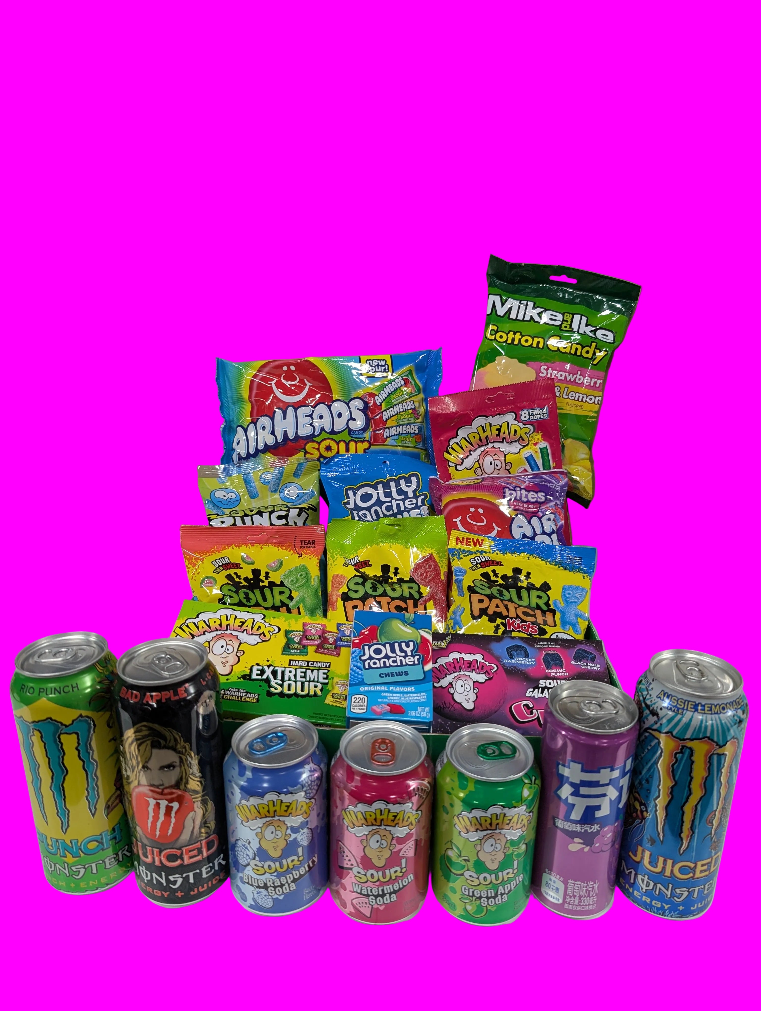 Assorted candy and energy drink cans on a white surface with a cardboard box in the background.